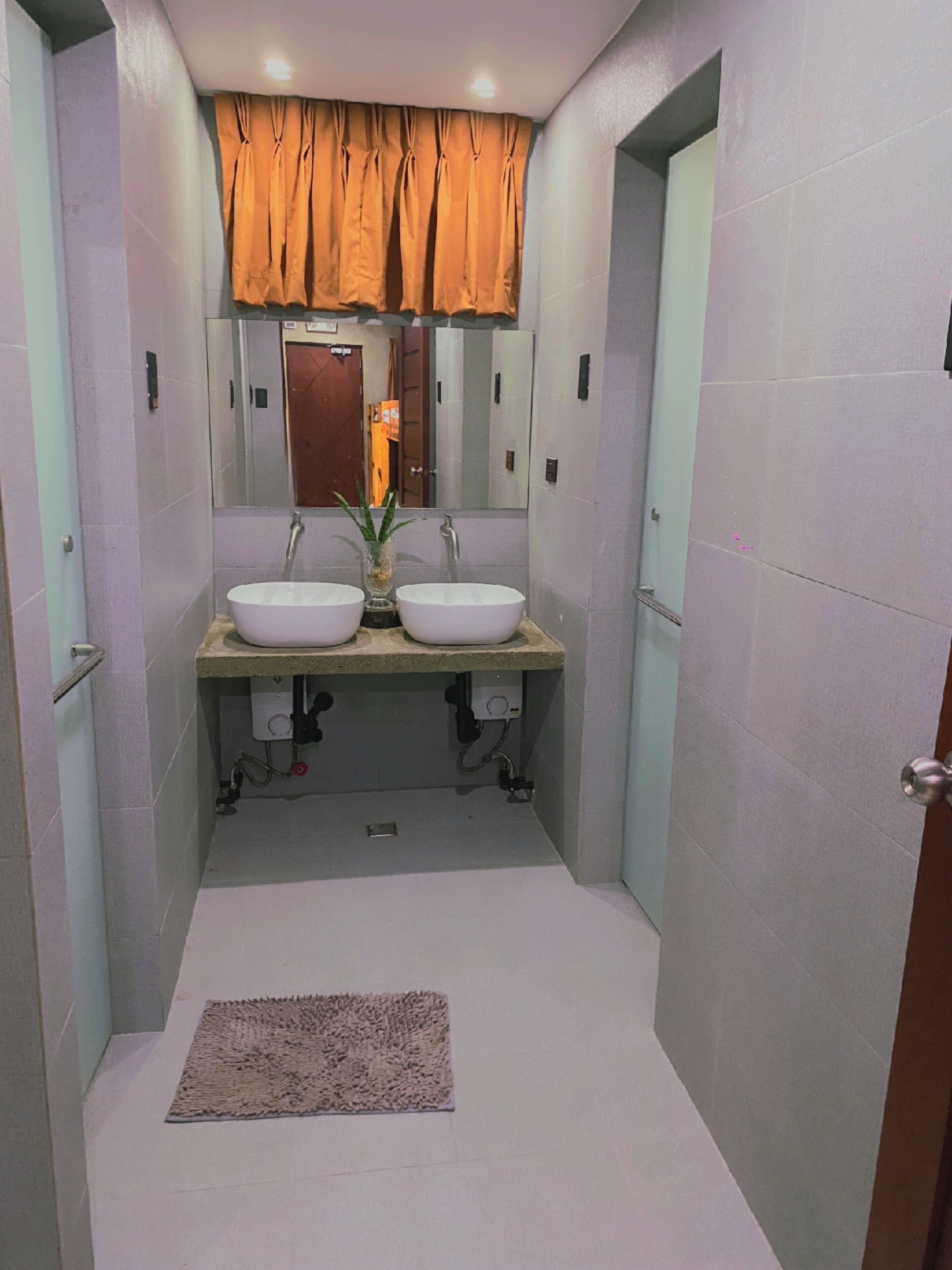 A bathroom with two sinks, a mirror, and a towel rack.