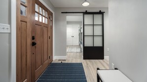 A hallway with wooden doors, a sliding glass door, and a blue rug. - 409 Paynter Avenue - In town Lewes with a private pool! (Lewes)