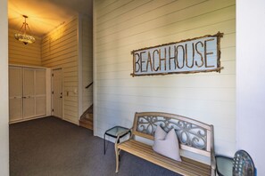 A hallway with a wooden bench, a small table, and a sign that reads 'BEACHHOUSE'. - Spacious 5-Bedroom Beach House with Stunning Views & Rooftop Deck (Folly Beach)