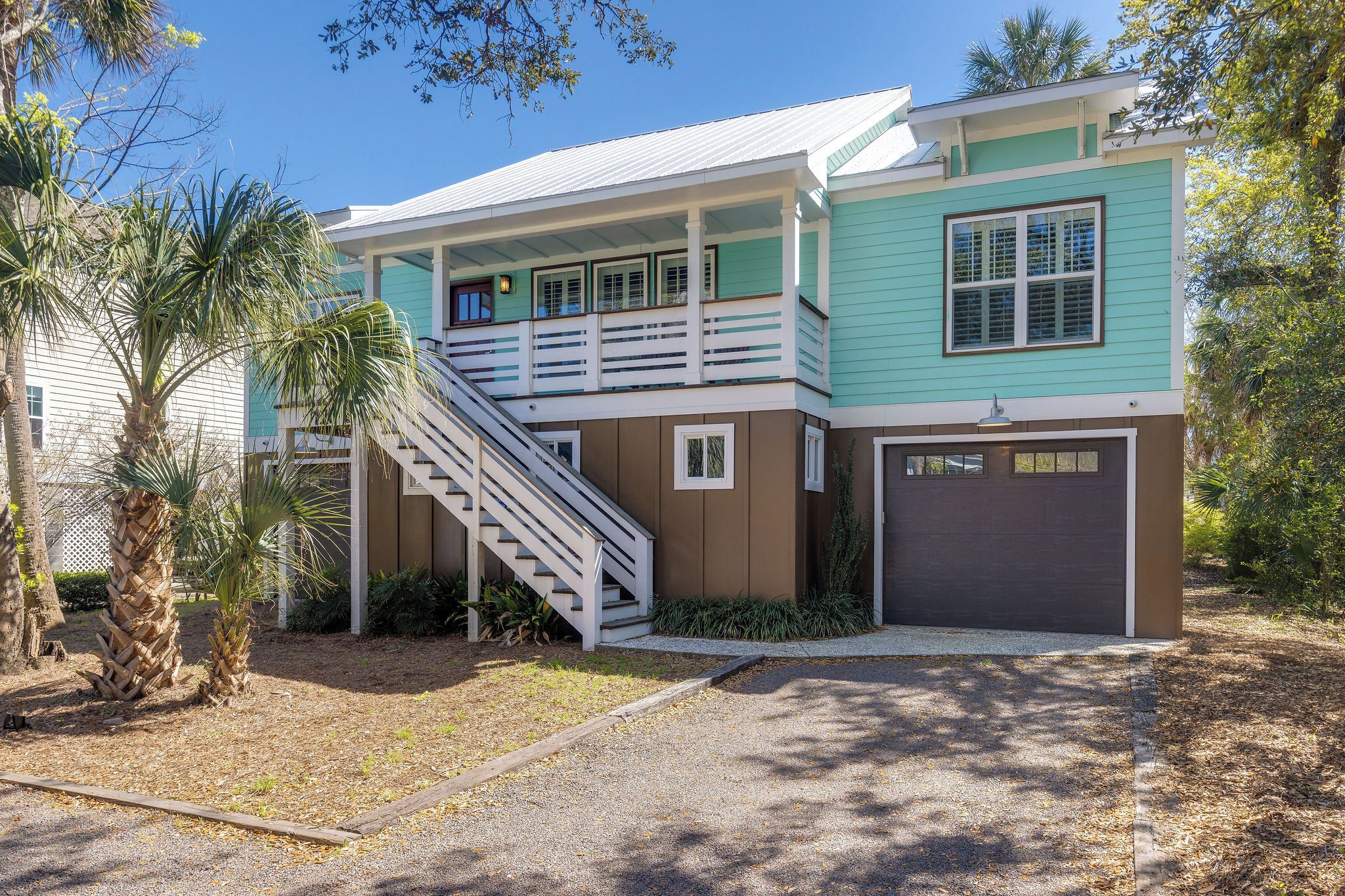 A two-story house with a covered porch, a staircase, and a garage.