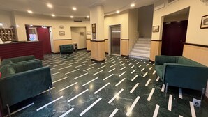 A lobby with a marble floor, green seating, a reception desk, and a staircase. - Palazzo Sant'Antonio Roma (Rome)