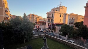 A courtyard with a statue, a bench, and a small garden area surrounded by buildings. - Palazzo Sant'Antonio Roma (Rome)