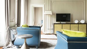 A living room with a blue sofa, a small round table, and a television.