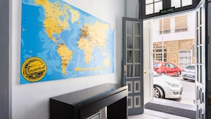 Una habitación con un mapa mundial en la pared, un escritorio y una puerta que da al exterior.