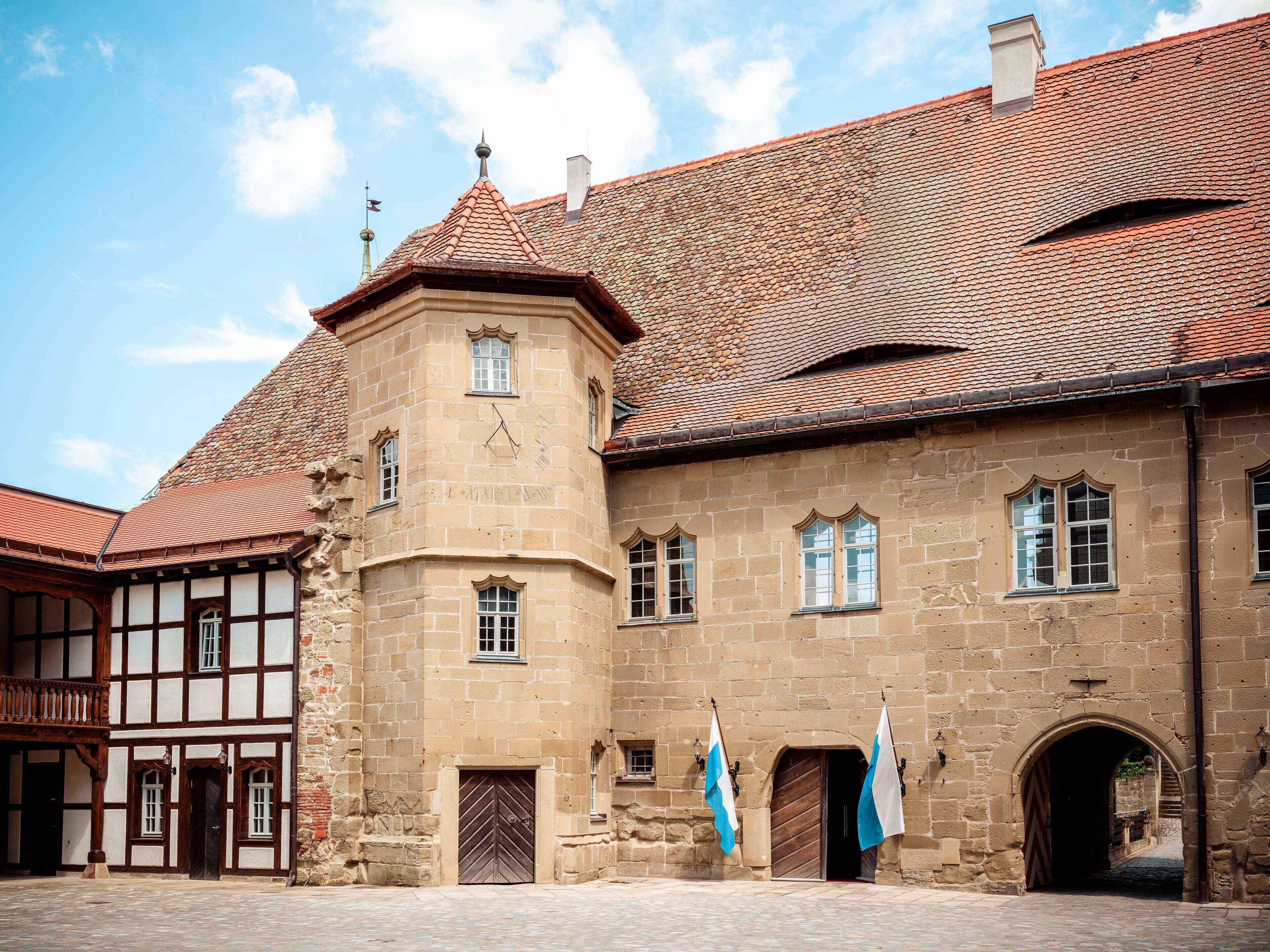 A historic building with a tower, multiple windows, and a traditional tiled roof.