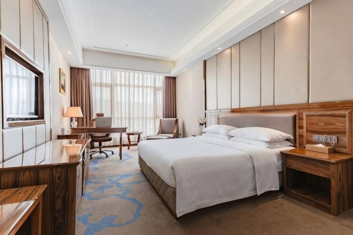Une chambre d’hôtel équipée d’un lit, d’un bureau, d’une chaise et d’un téléviseur.