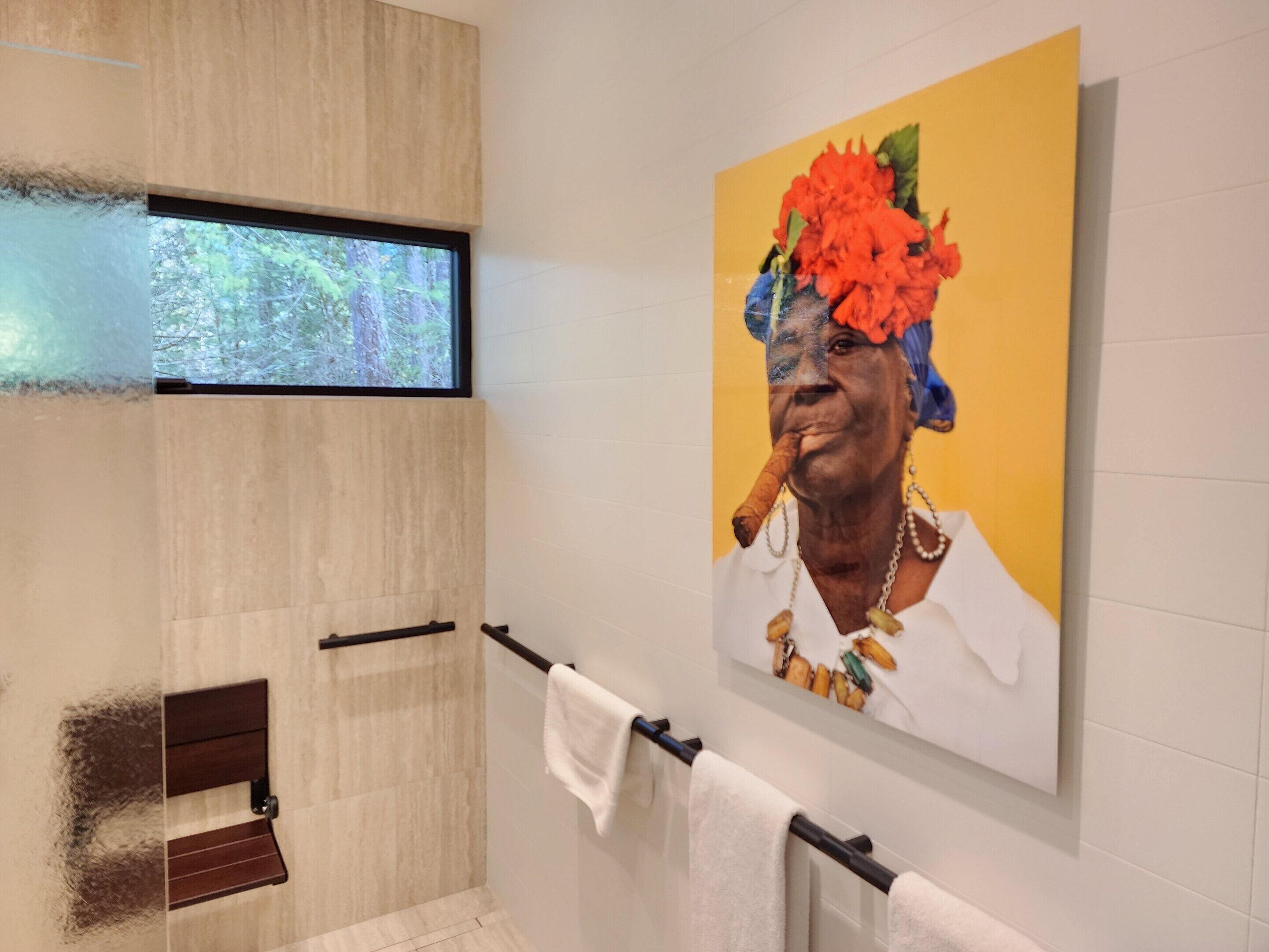 A bathroom with a shower, a towel rack, and a window.