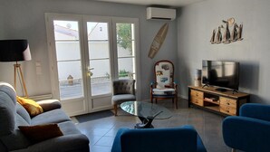 Un soggiorno con un divano, un tavolino, una TV e una poltrona.