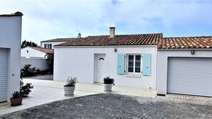 Una casa a due piani con tetto in tegole, un garage e vialetto in pietra.