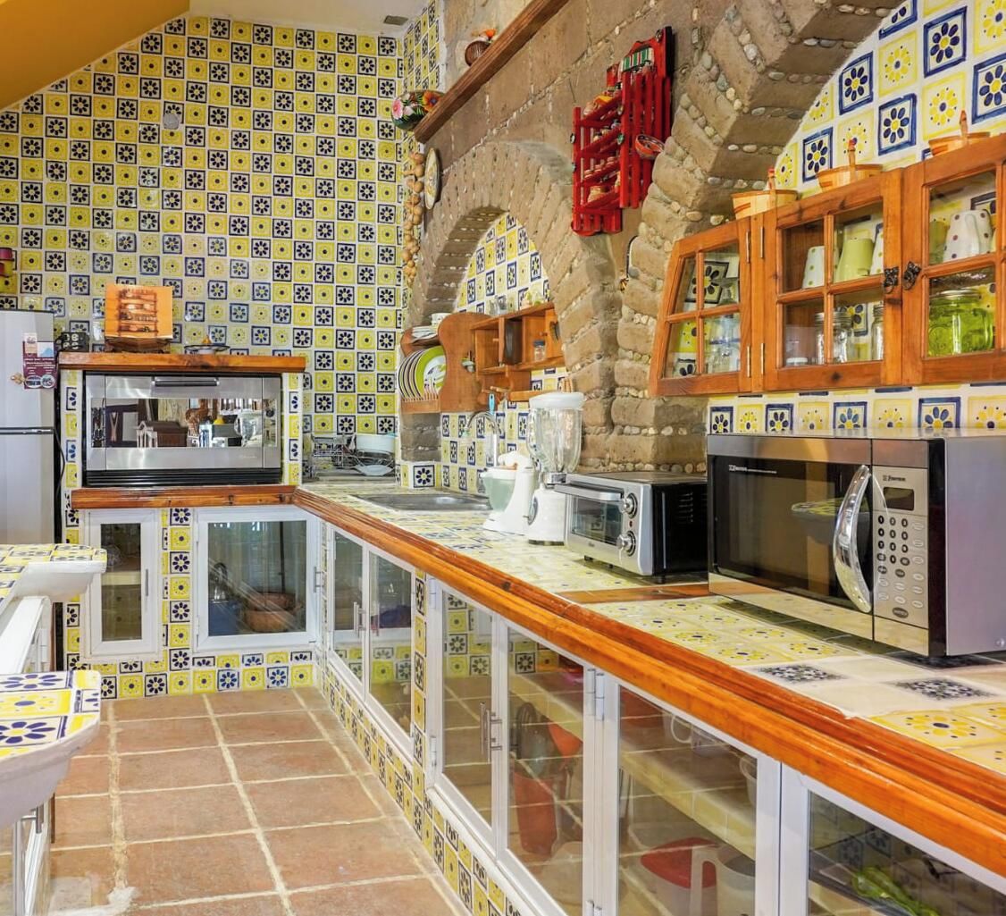 A kitchen with a tiled backsplash, wooden cabinets, and modern appliances.
