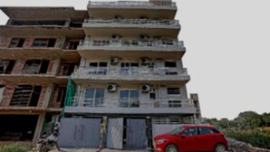 A multi-story building with balconies and air conditioning units. - Hotel Collection Inn (Gurugram)