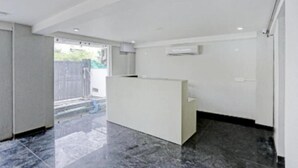 A reception area with a reception desk, a tiled floor, and a wall-mounted air conditioning unit. - Hotel Collection Inn (Gurugram)