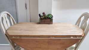 Ein Esstisch mit vier Stühlen, eine kleine Pflanze darauf und eine Steckdose an der Wand.