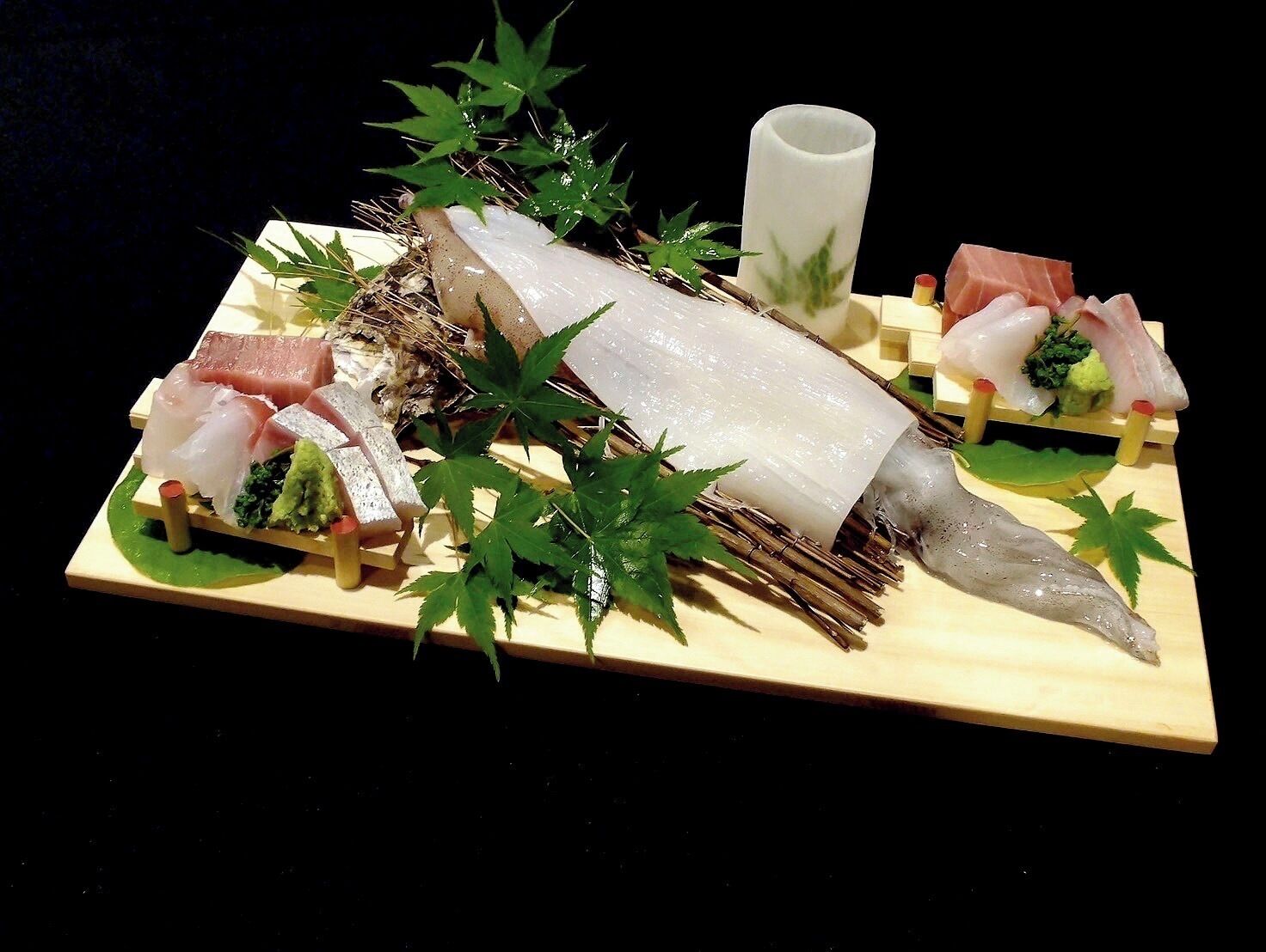 A sushi platter with various types of fish and garnishes.