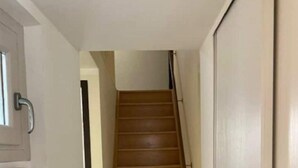 A staircase leading to an upper floor, with a handrail on the right and a door on the left. - Appartement en Duplex Centre Historique (Montpellier)