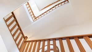 A wooden staircase with a skylight leading to an upper floor.