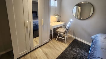 Un dormitorio con cama, escritorio, silla y armario.
