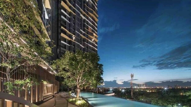 A modern building with a rooftop pool, wooden walkways, and a view of the city skyline at dusk. - Excellent location, best facilities ,worth to pay (Jatujak)
