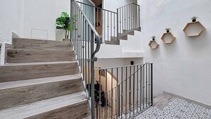 Eine Treppe mit Holzbodenstufen und Metallgeländern, die zu einer oberen Etage führt.
