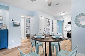 A modern kitchen with a dining area, a washing machine, and a microwave. - Fully Renovated, First Floor Villa "Just Beachy" (Hilton Head Island)