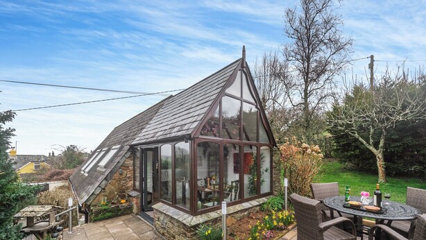 A conservatory with a sloped roof, a stone exterior, and a glass door. - 1 bedroom accommodation in Burraton, near Ivybridge (Burraton, near Ivybridge)