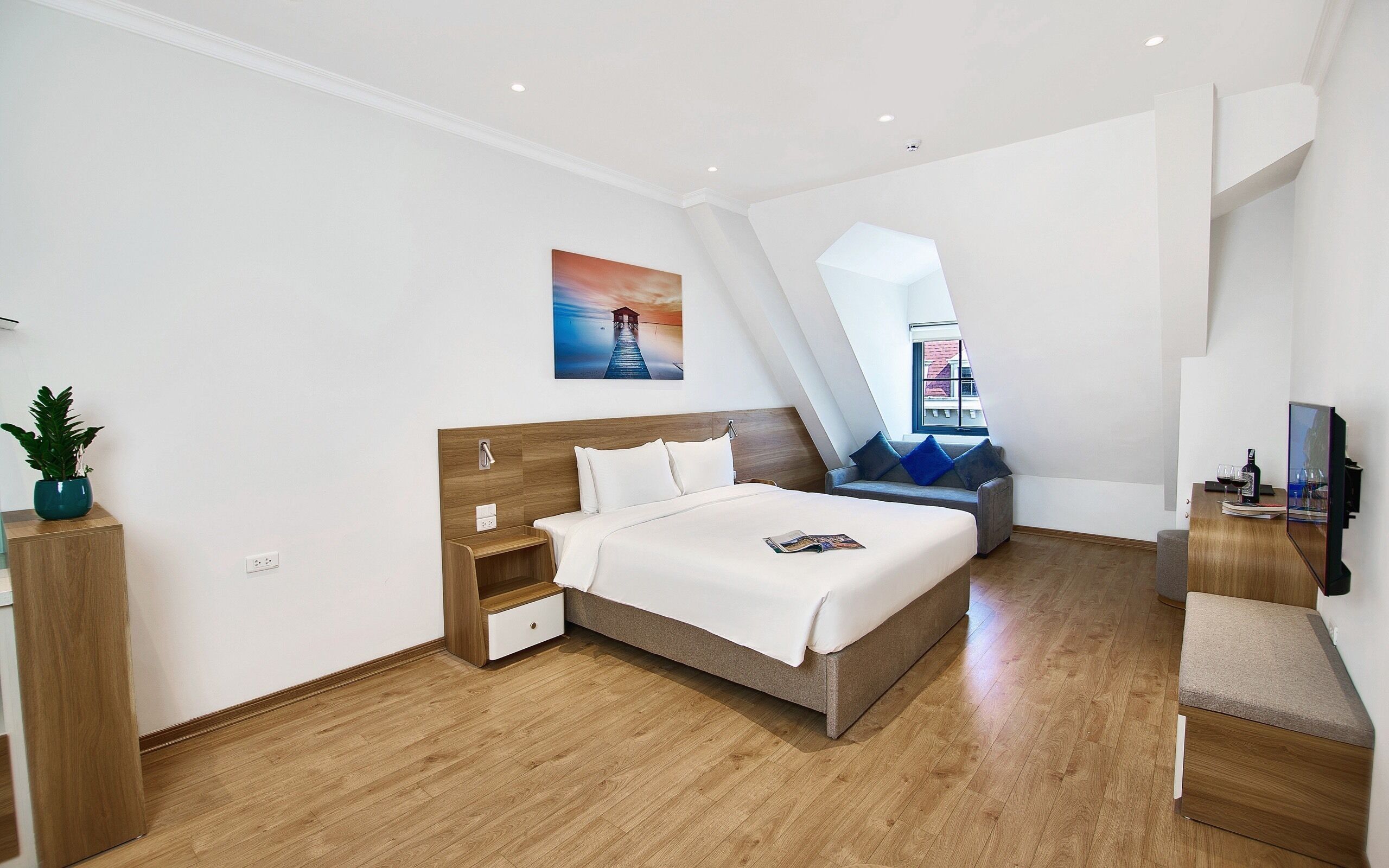 Une chambre d’hôtel moderne équipée d’un grand lit, d’un bureau, d’une chaise et d’une télévision.