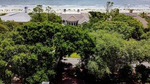 A coastal property with a view of the ocean, surrounded by dense greenery.