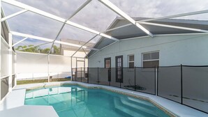 En overdækket swimmingpool med hvid facade og tagkonstruktion.