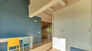 A modern interior with a dining area, a staircase, and a wardrobe. - Melograno Apartment - Poggio le Crete (Soiano)