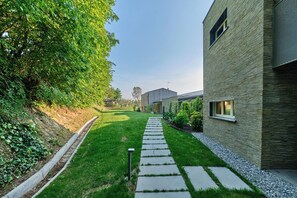 A modern building with a stone facade and a well-maintained lawn.