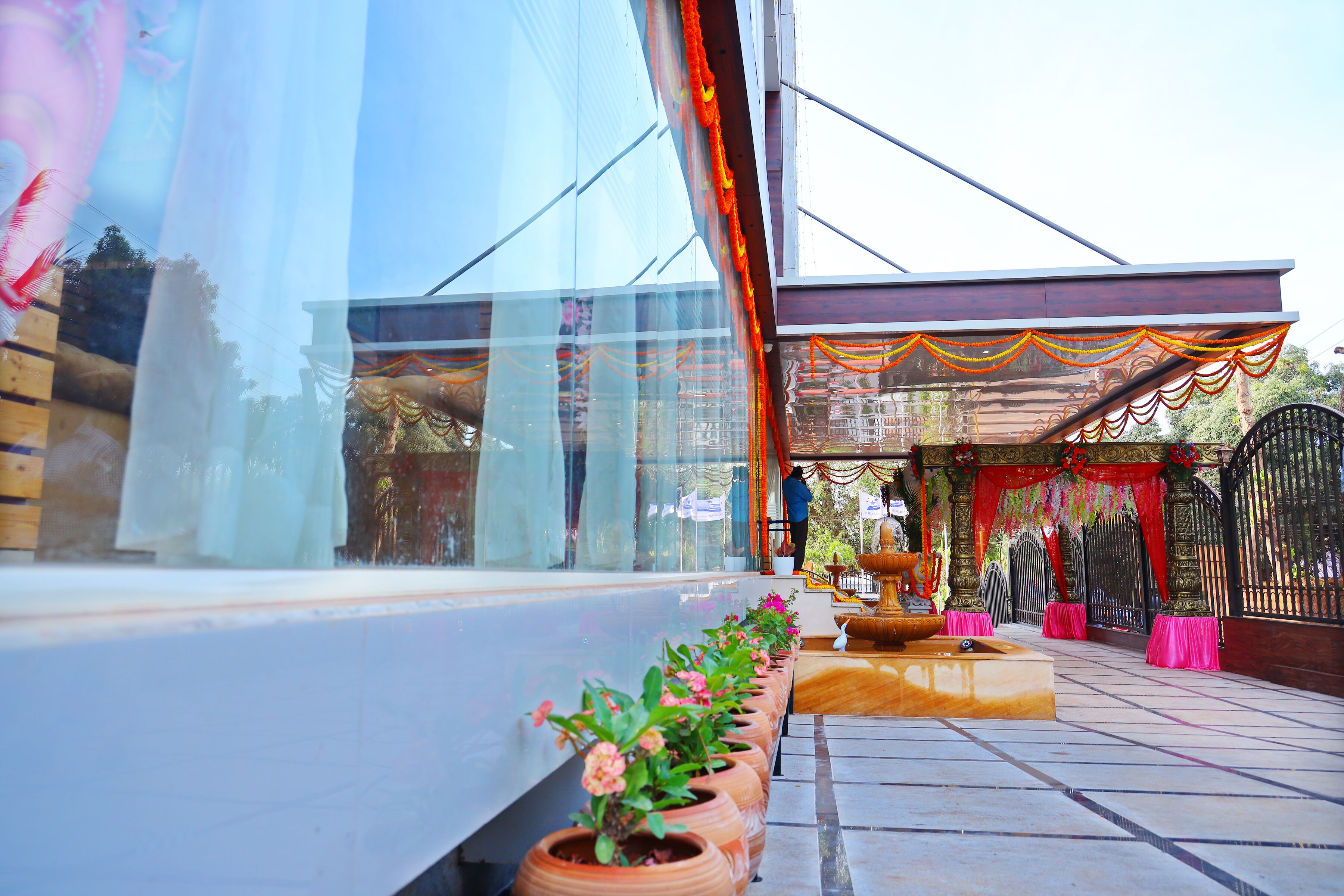 A modern building with a glass facade, a tiled entrance area, and a decorative archway.