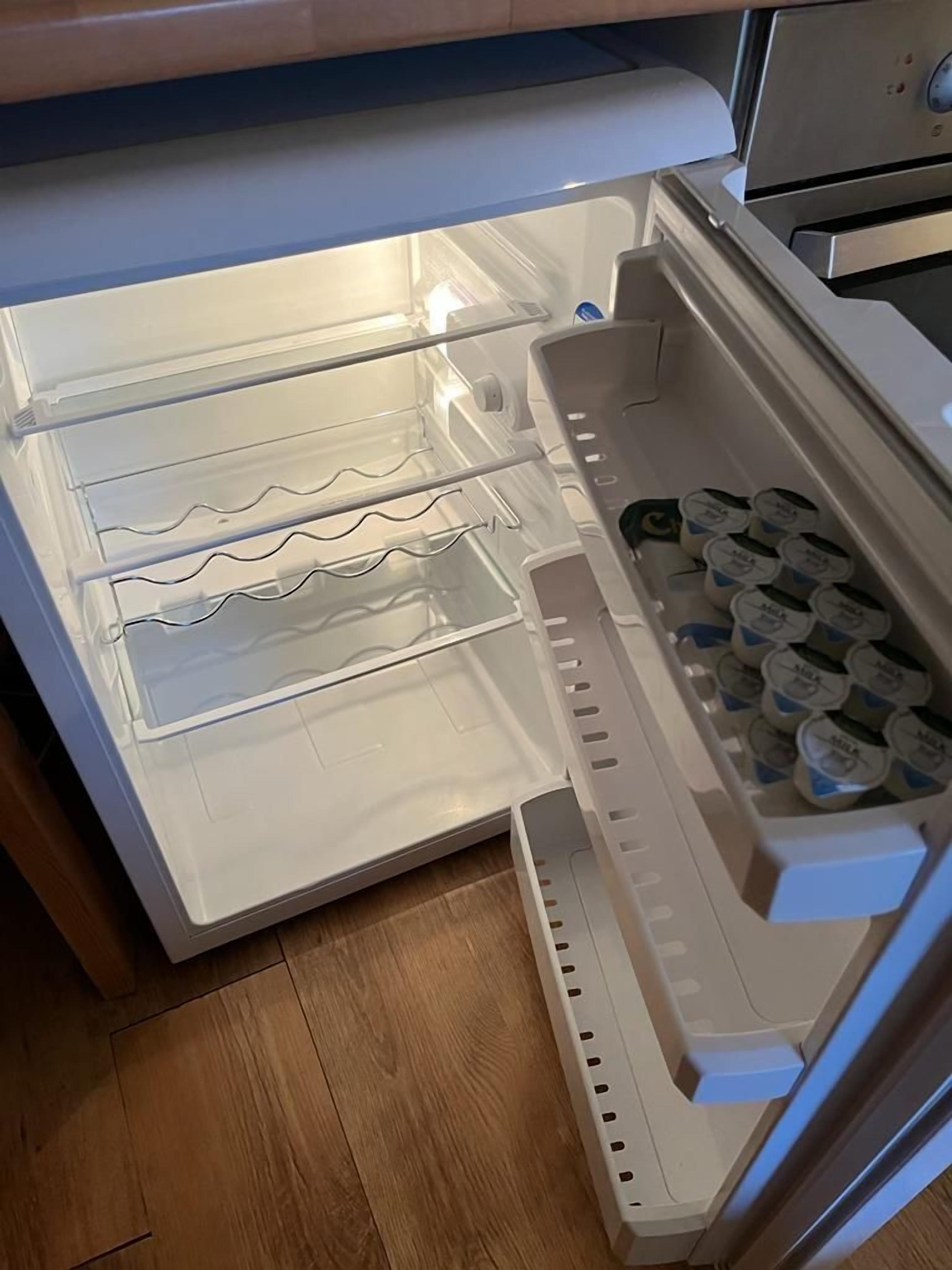 An open refrigerator with shelves and a freezer compartment.