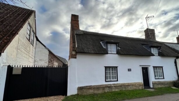 A traditional white building with a black roof, a black gate, and a small garden area. - Two Storey Annex (Cambridge)
