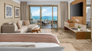 Una habitación de hotel moderna con una cama grande, un sofá, un televisor y un balcón con vistas al mar.
