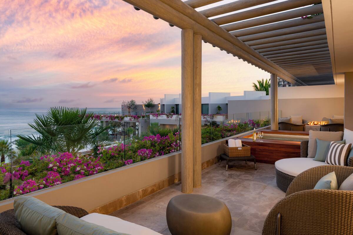 A rooftop terrace with outdoor seating, a pool, and a view of the ocean.