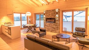 A modern log cabin interior with a kitchen, dining area, and living room.