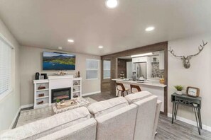 Relax in this stylish living room with a large flat-screen TV, fireplace, and comfortable sofa.