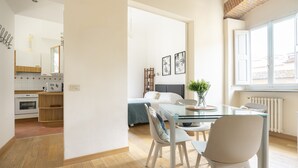 A modern kitchen with white cabinets, a built-in oven, and a wooden countertop.