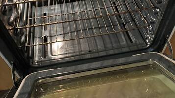 Un horno abierto con una rejilla y una bandeja para hornear.