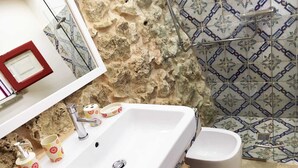 Un baño con lavamanos blanco, inodoro y zona de ducha.
