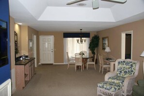 Relax in this inviting living area with a dining table, armchair, and potted plant.