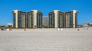 A large, multi-story hotel with a symmetrical facade, located on a sandy beach. - 🏖️Stunning Gulf Views | 3 Pools | Sunbird 709W- Beach Life🏖️ (Panama City Beach)