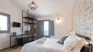 Une chambre à coucher moderne, équipée d’un lit, d’une télévision, d’un bureau et d’une armoire.