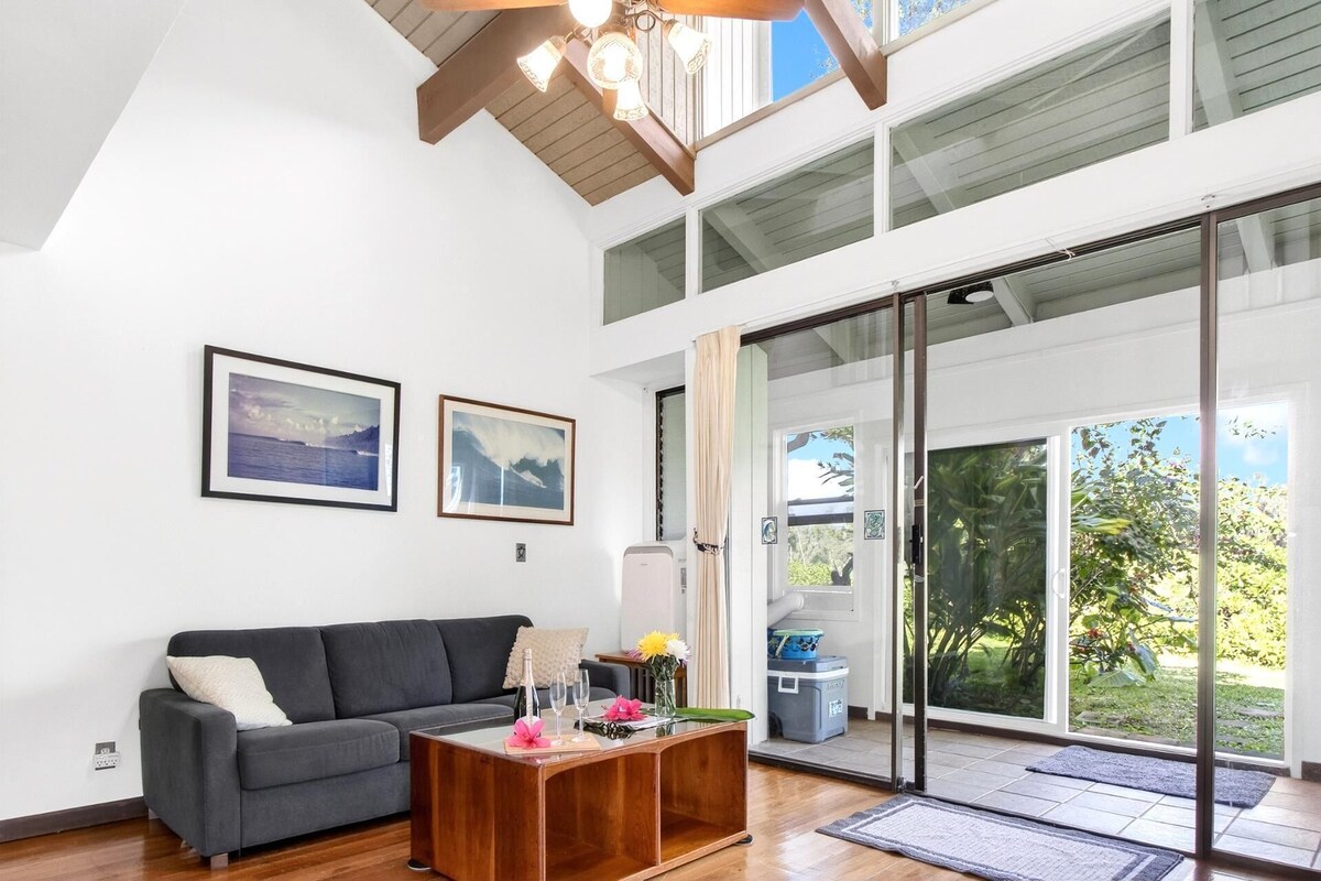 A modern living room with a gray sofa, wooden coffee table, and two framed pictures on the wall.