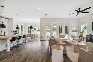 A spacious kitchen with a central island, bar seating, and a dining area with a sofa and chairs.