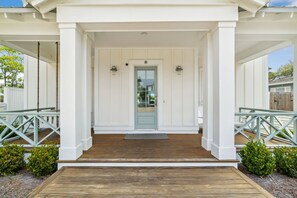 Guests can enter through the front door, which is flanked by wall-mounted lights.