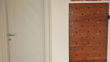 Una porta bianca con motivo strutturato e una porta in legno con chiodi metallici.