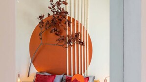 Ein modernes Schlafzimmer mit Bett, Kissen, einer Wanddekoration und einem Spiegel.