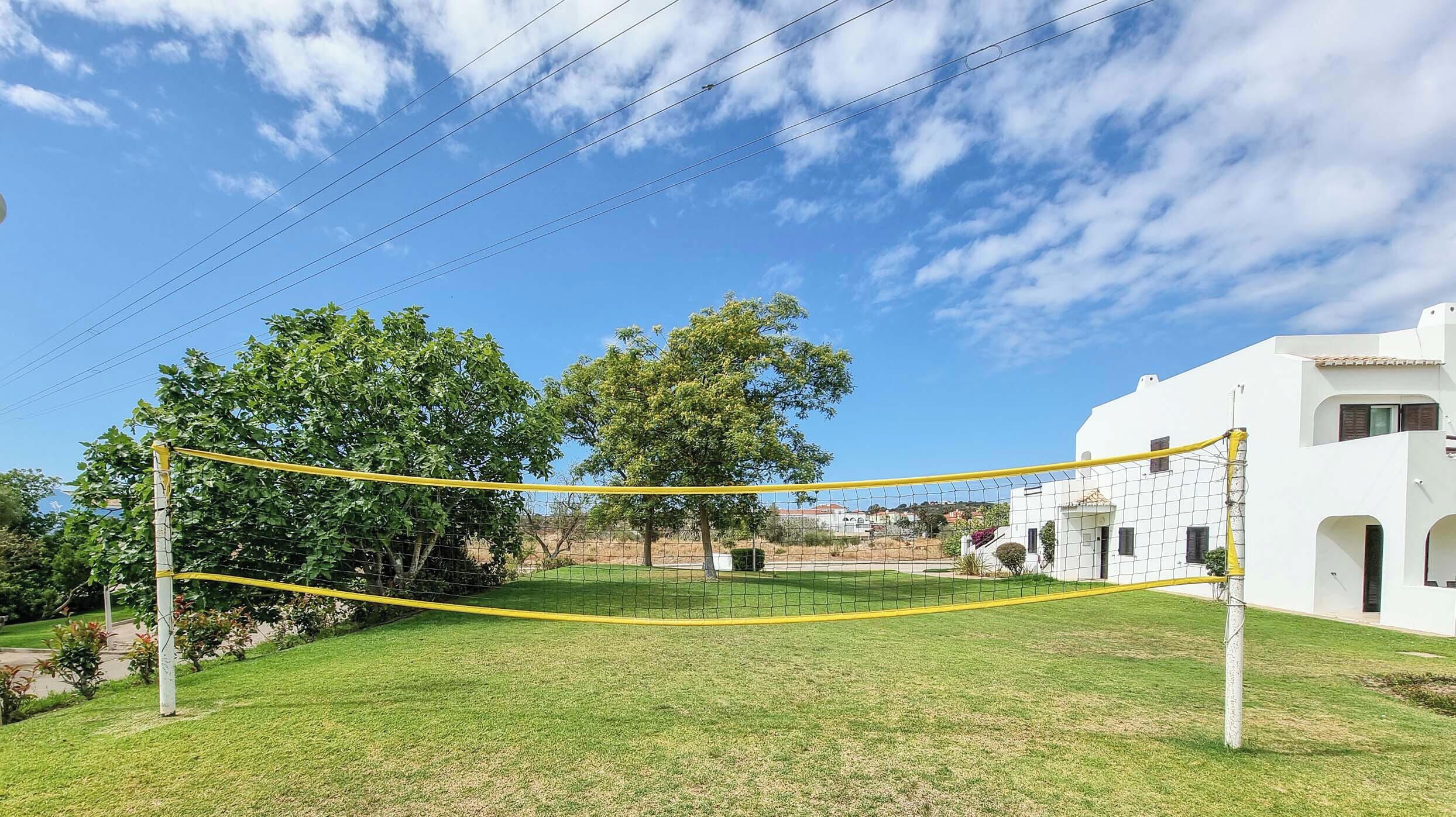 A netted volleyball court with a white building in the background.
