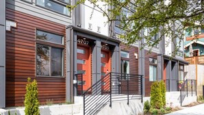 A modern apartment building with two-story structures, numbered 4707 and 4709, featuring a combination of wood paneling and concrete.